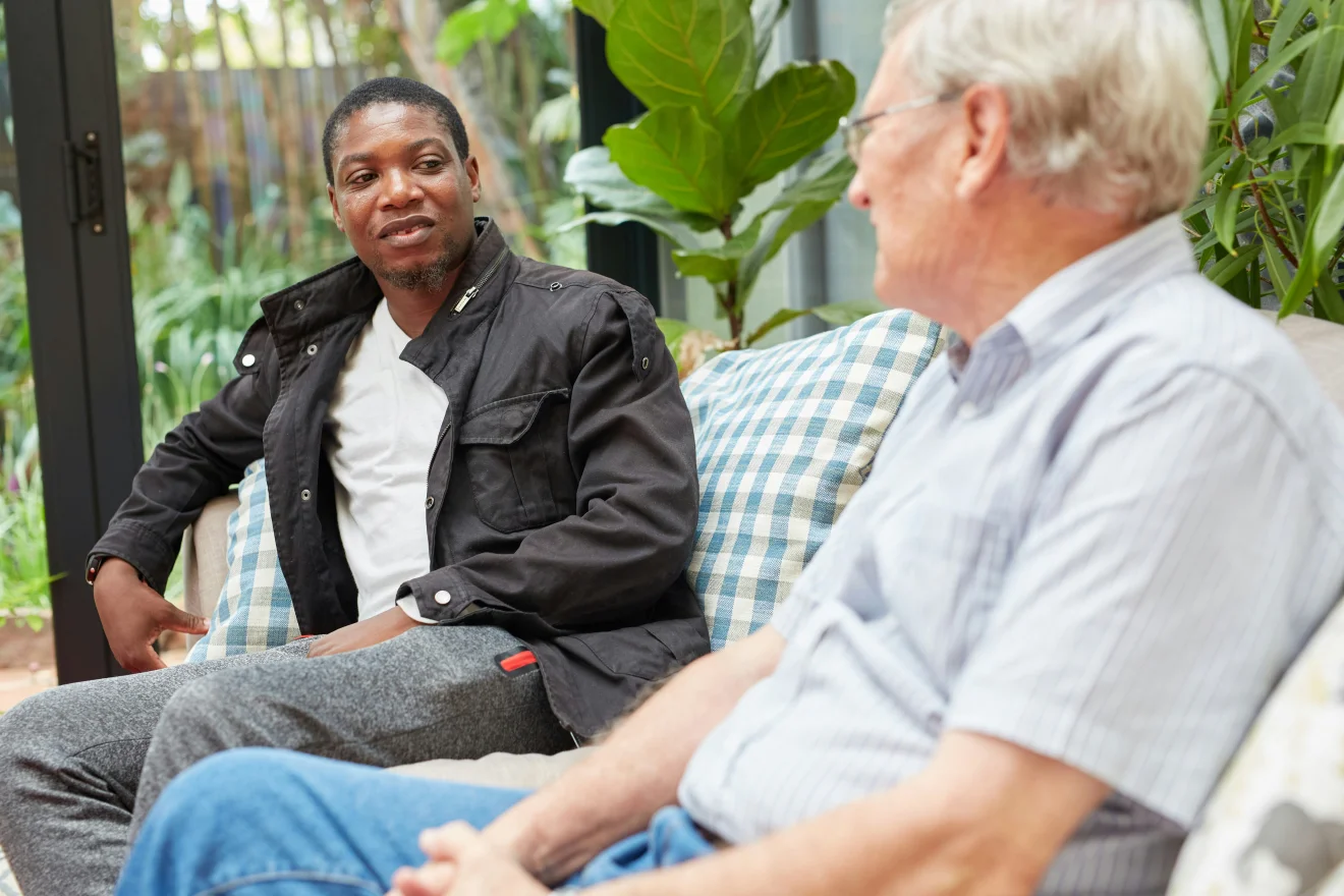 A woman talking with an older man.