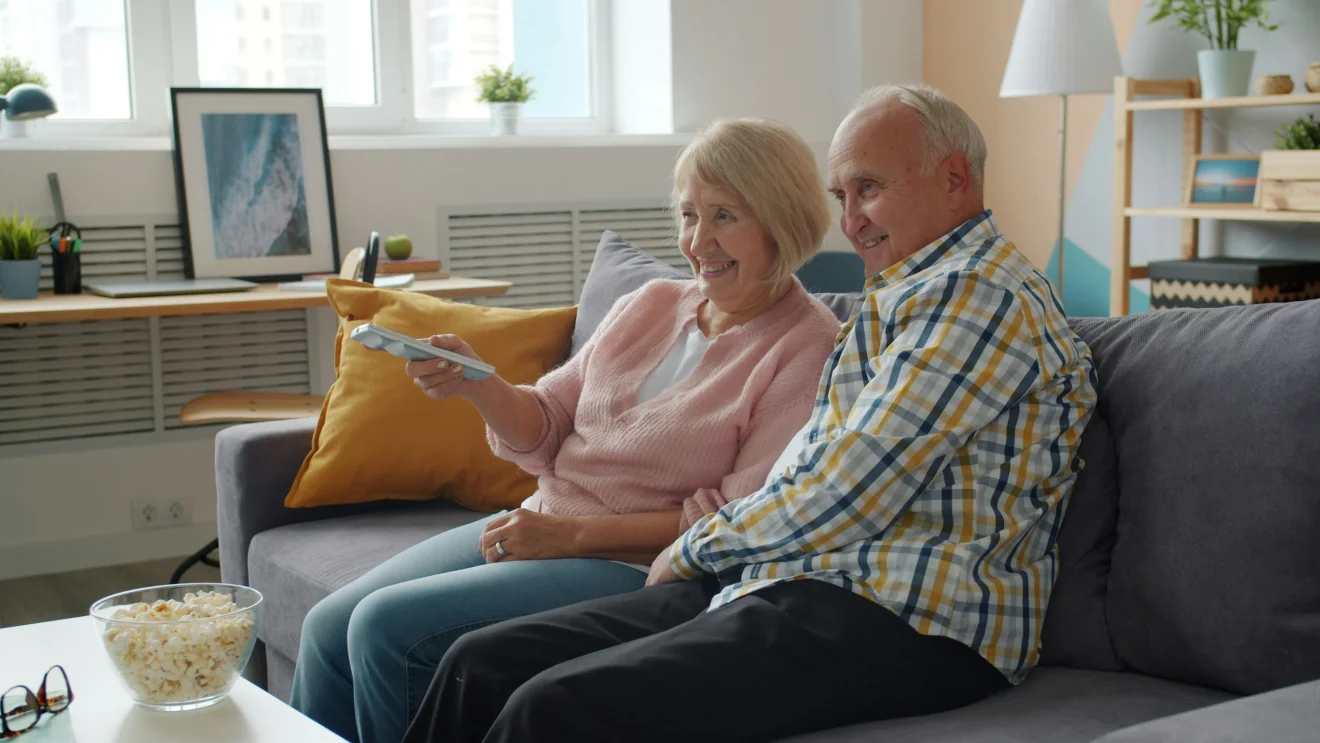 An older couple sitting together at home.